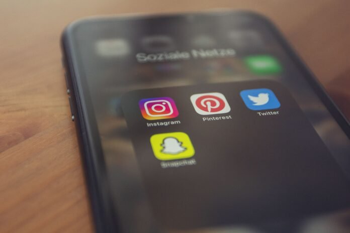 Un celular cuya pantalla muestra íconos de redes sociales.