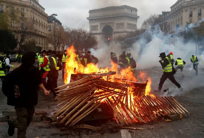 Manifestantes en Francia quemando elementos en el centro de la calle.